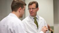 Dr. Guy McKhann speaks with another doctor